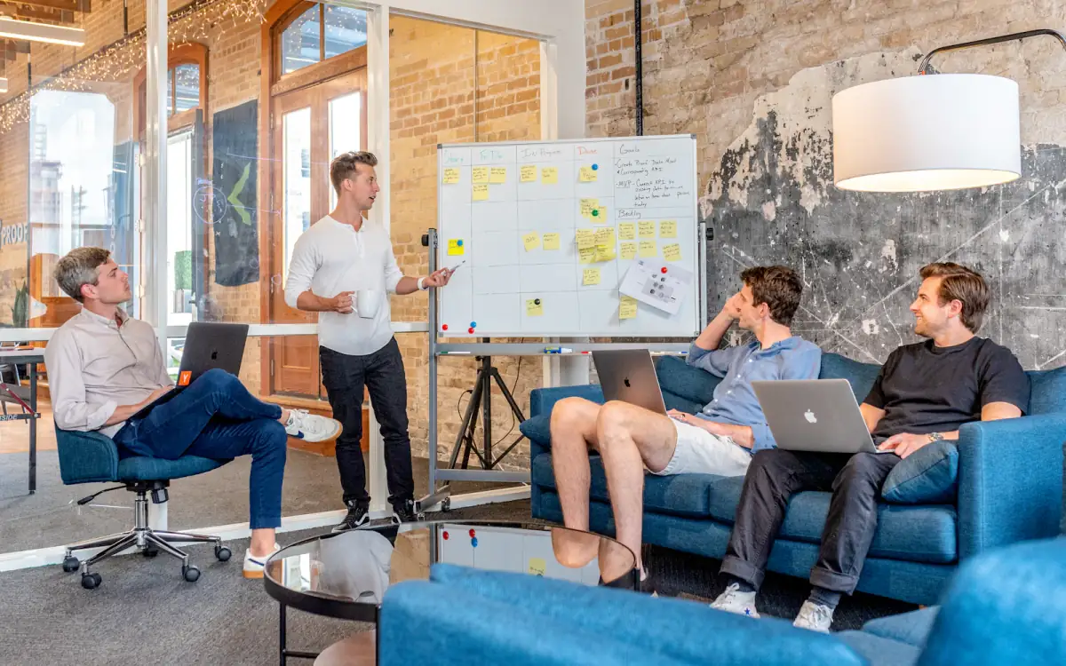 A team discussing a plan in front of a whiteboard